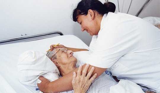 Krankenschwester am Bett mit Patientin
