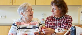 Zwei Frauen bereiten in der Küche gemeinsam Erdbeeren vor.