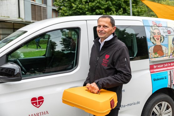 Mitarbeiter des Seniorenzentrums Lichtenstein-Honau mit Essen auf Rädern vor Lieferwagen.