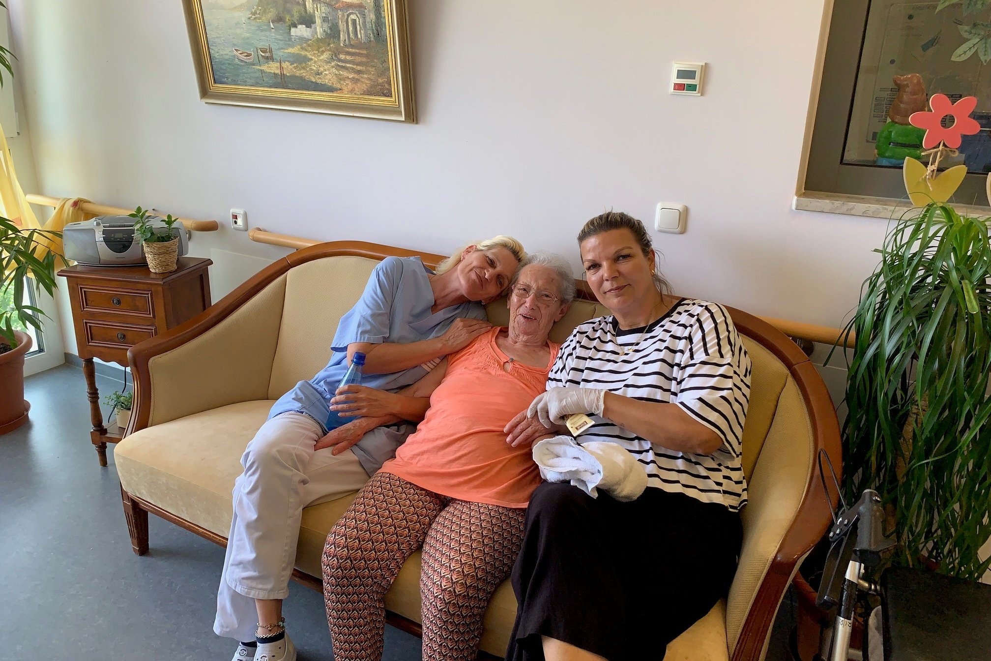 Bewohnerin und Pflegerinnen auf Sofa im Seniorenzentrum Eckental.