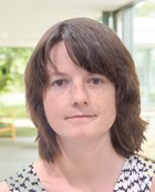 Porträtfoto einer Person mit kurzem braunem Haar und neutralem Gesichtsausdruck.