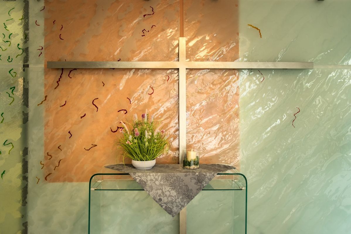 Dekoratives Kreuz mit Blumenarrangement auf einem Tisch im Seniorenzentrum Stuttgart.