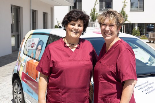 Zwei Pflegekräfte vor dem Auto der Diakoniestation im Seniorenzentrum Martha-Maria Lichtenstein-Honau