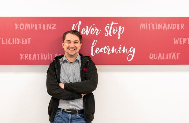 Franjo Bozic vor einer Wand im Seniorenzentrum Martha-Maria Stuttgart mit der Aufschrift Never Stop Learning