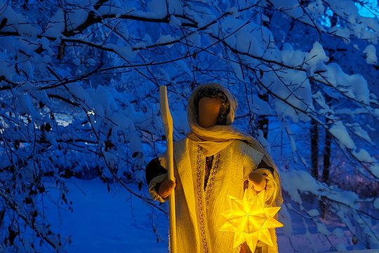 Eine Egli-Figur mit Stern in der Hand im Schnee.