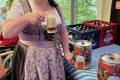 Frau in traditioneller Tracht serviert Bier im Seniorenzentrum Eckental.