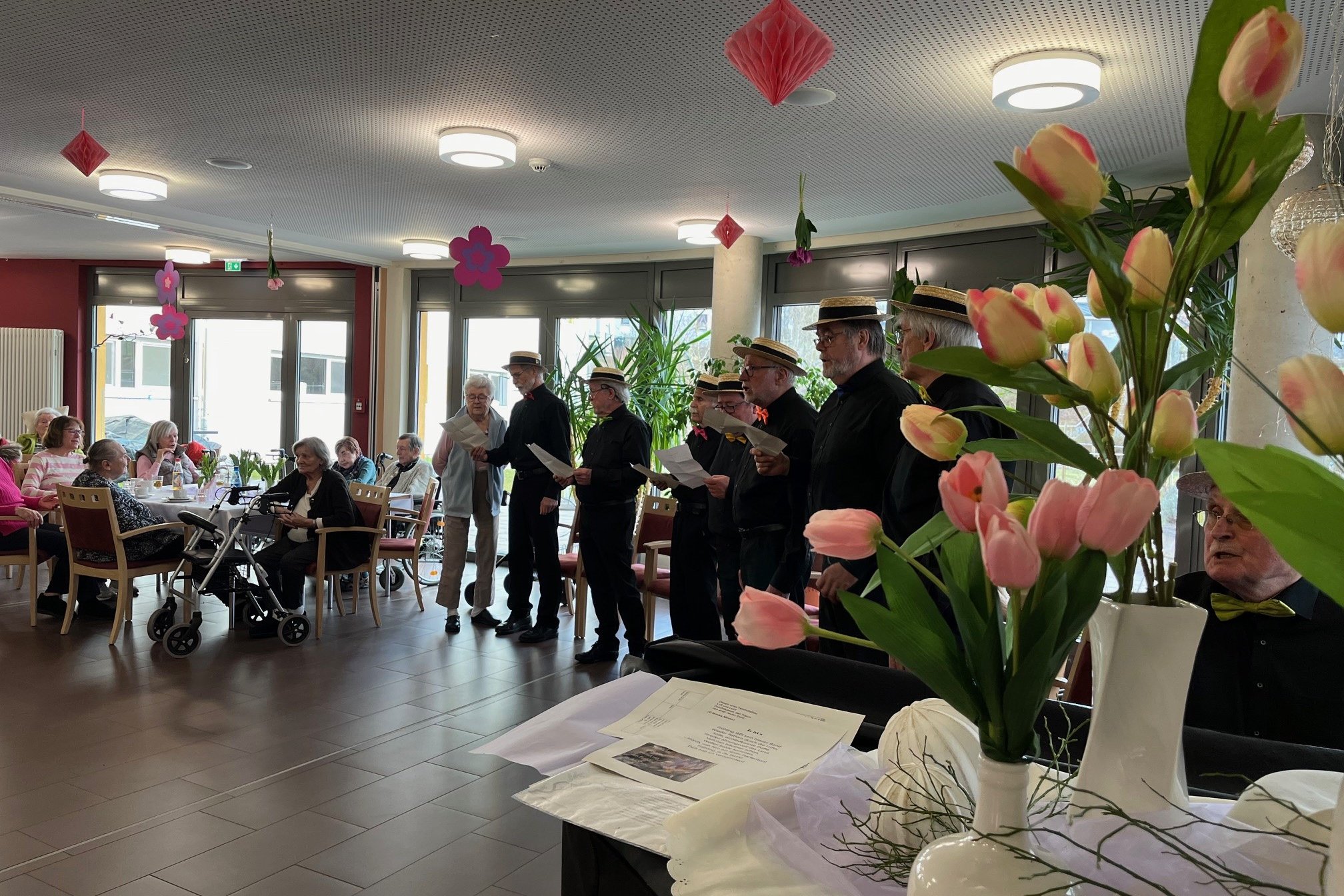 Seniorenchor singt im Seniorenzentrum Eckental, dekorierter Raum mit Tulpen.