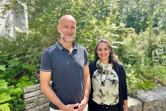 Zwei Personen im Garten der Klinik für Orthopädie und Unfallchirurgie Nürnberg.