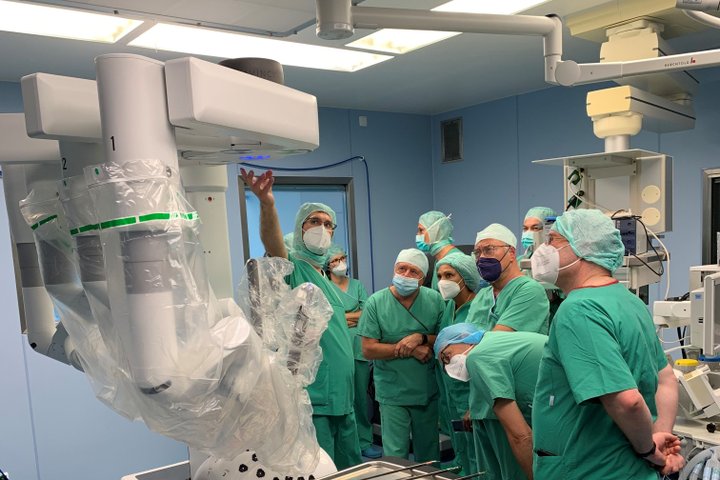 Ärzte in OP-Kleidung bei einer Roboterchirurgie-Schulung im Operationssaal.