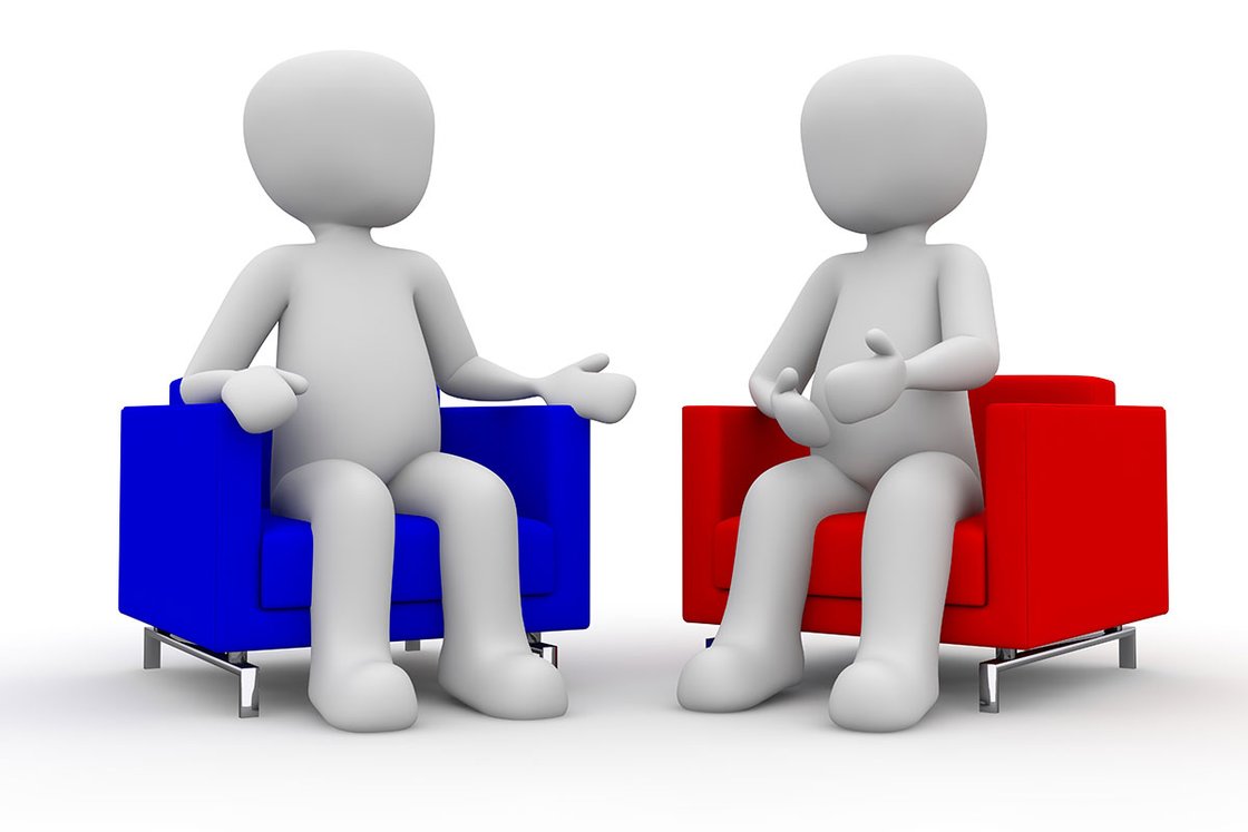 Zwei 3D-Figuren sitzen auf blauen und roten Sesseln im Gespräch.