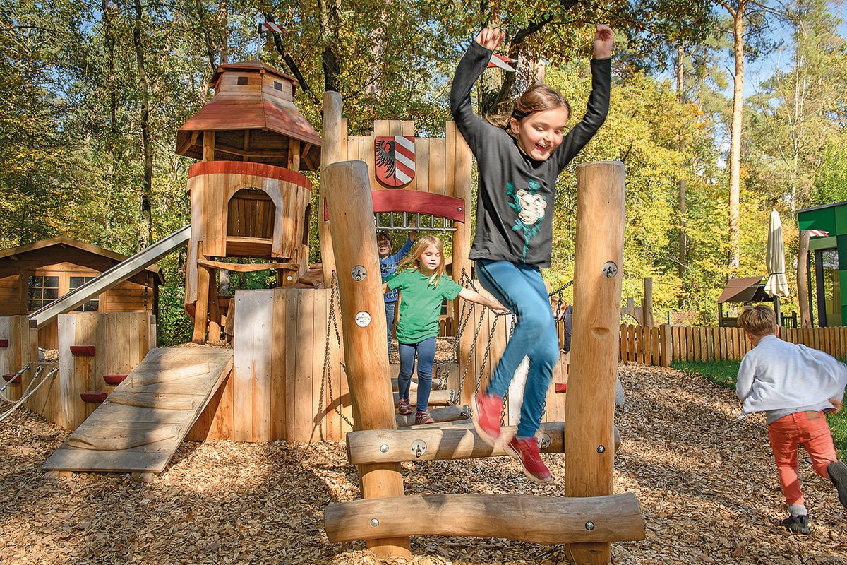 Ein Mädchen springt von der Spielburg in der Martha-Maria Kindertagesstätte in Nürnberg.