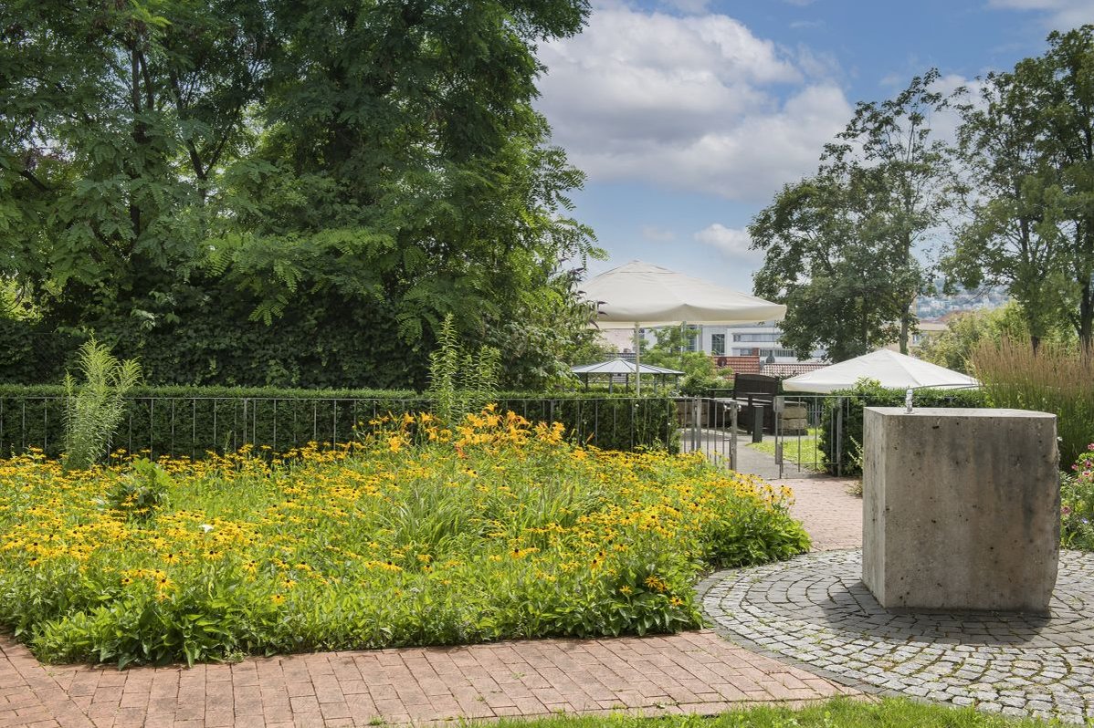 Blühender Garten mit Sonnenschirmen im Seniorenzentrum Stuttgart.