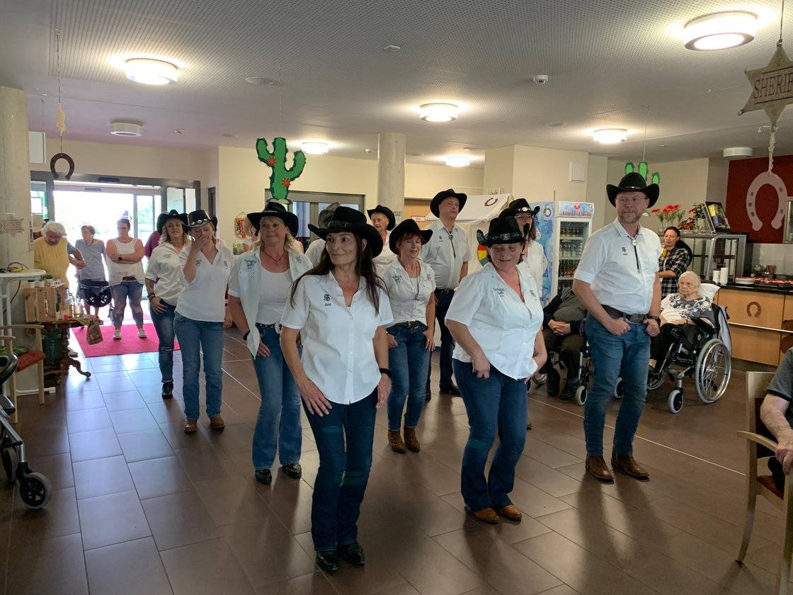 Seniorenzentrum Eckental, Bewohner und Besucher beim gemeinsamen Line-Dance im Gemeinschaftsraum.