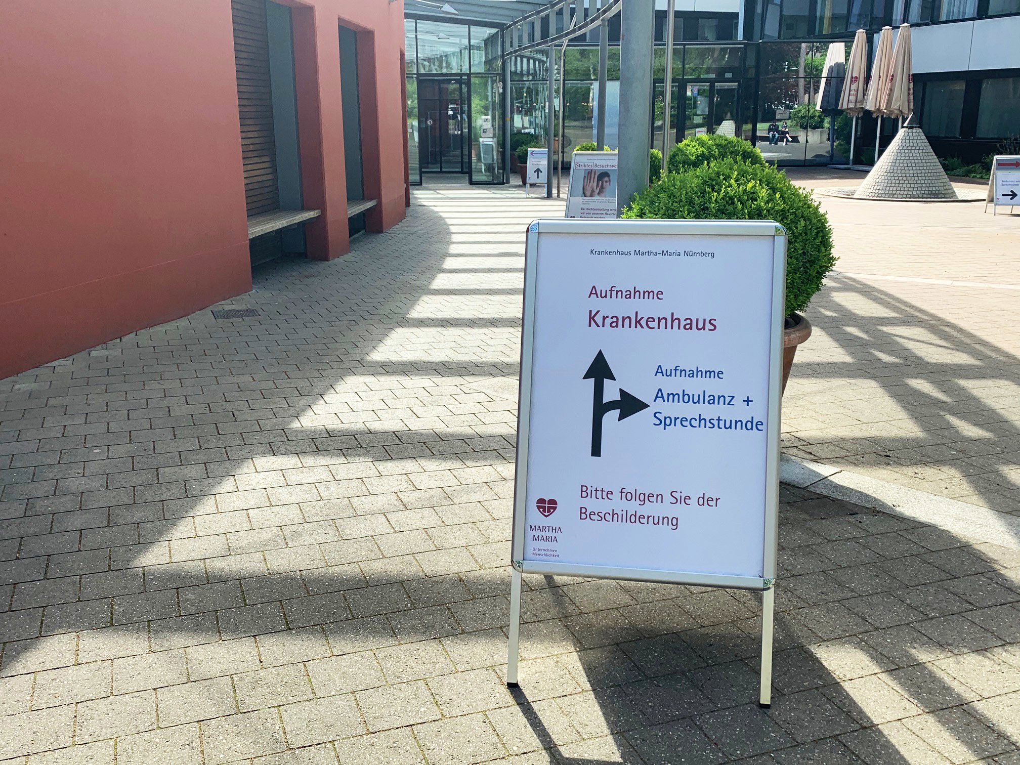 Eingang Krankenhaus Martha-Maria Nürnberg mit Hinweisschild zur Ambulanz.
