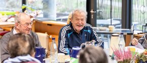 Lachende Bewohner im Seniorenzentrum Martha-Maria Lichtenstein-Honau bei Kaffee und Kuchen.
