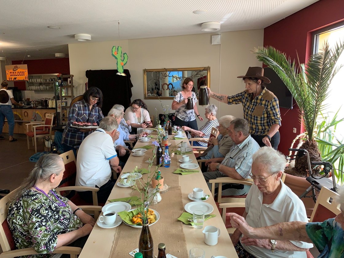 Senioren beim gemeinsamen Kaffeetrinken im Seniorenzentrum Eckental, betreut von Mitarbeitern.