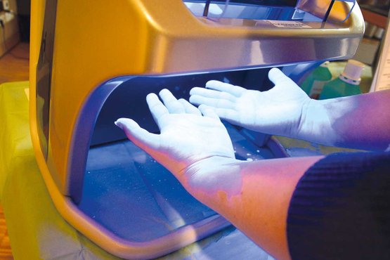 Eine Mitarbeiterin bei der Kontrolle der Handhygiene