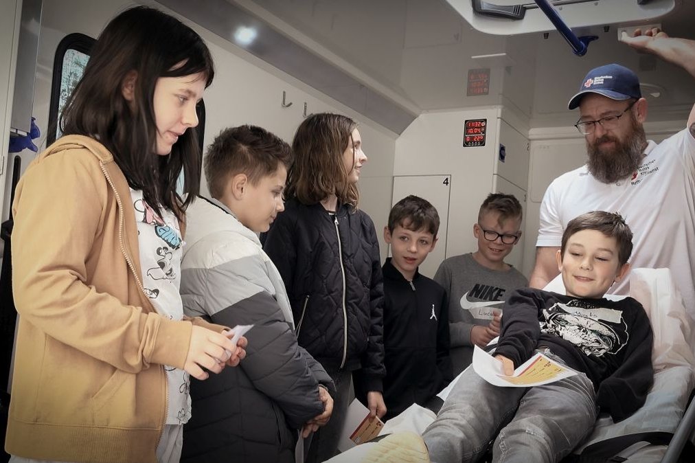 Kindergruppe lernt in Krankenwagen mit Sanitäter, Projekt Jonas will's wissen.
