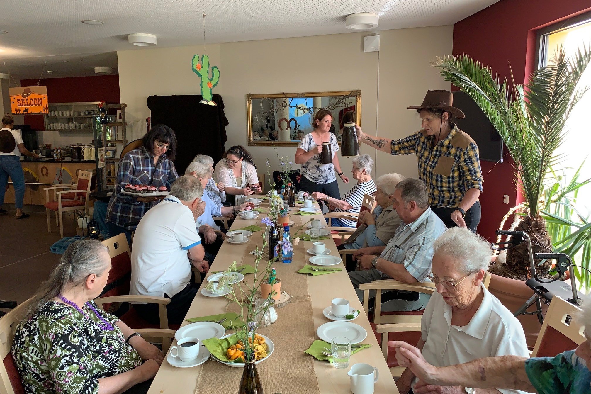 Senioren beim gemeinsamen Kaffeetrinken im Seniorenzentrum Eckental, betreut von Mitarbeitern.
