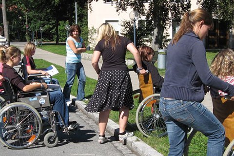Gruppe von Menschen mit Rollstühlen übt im Freien.