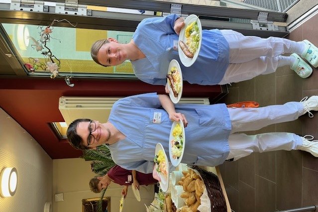 Zwei Mitarbeiterinnen des Seniorenzentrums Eckental servieren Essen auf Tellern.