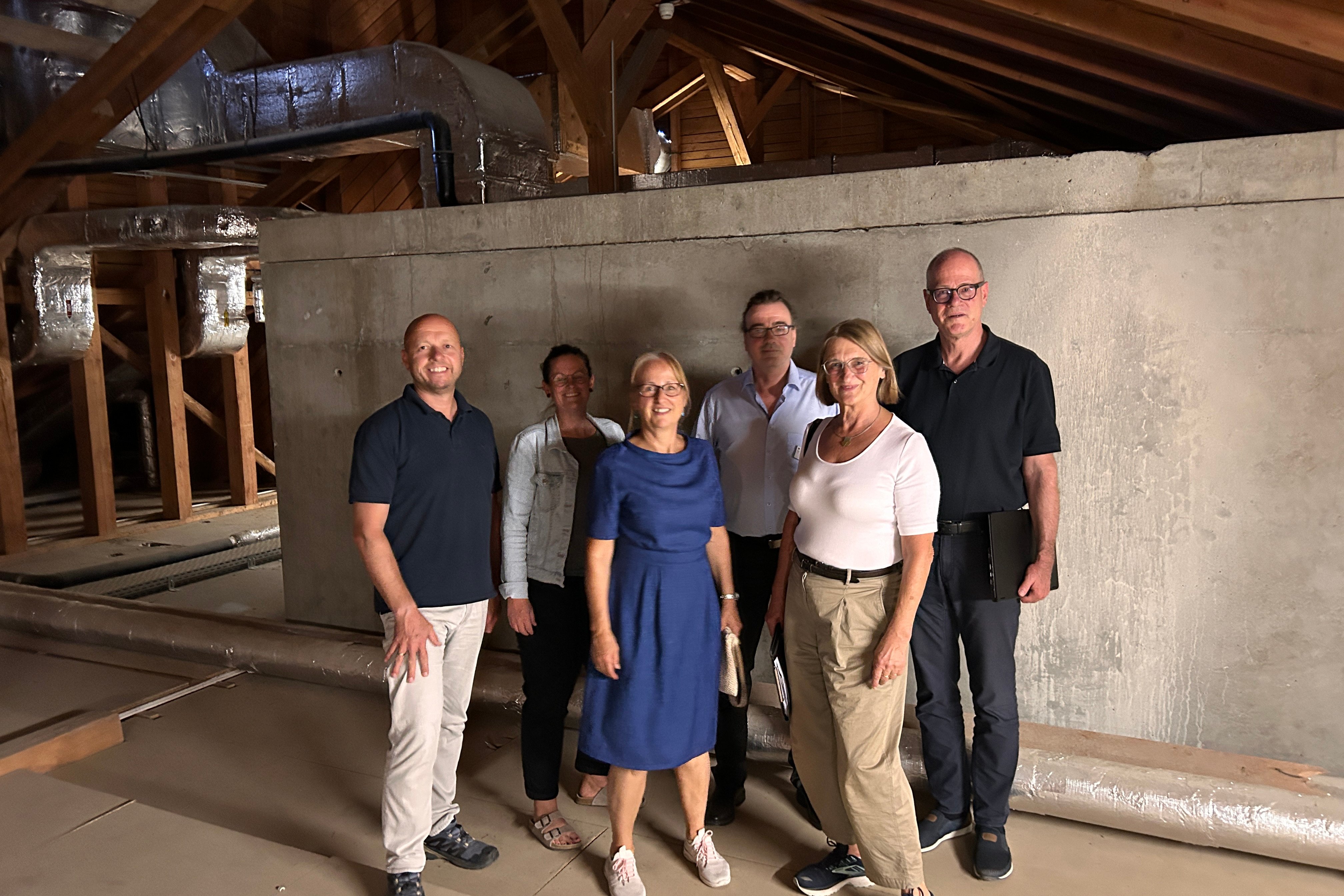 Gruppe von Personen im Dachboden des Seniorenzentrums zur Klimaanpassungsinspektion.