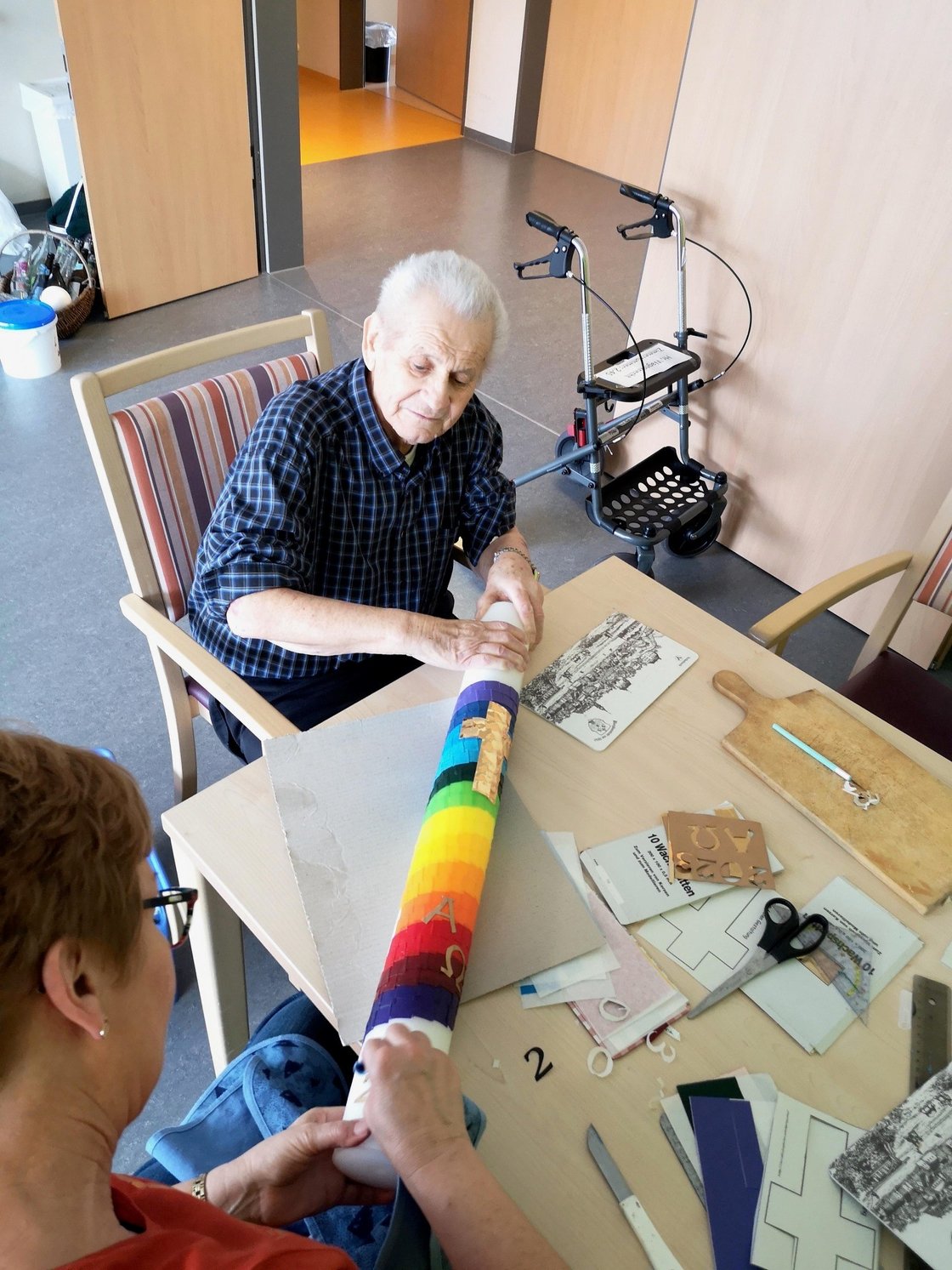 Senior dekoriert bunte Kerze im Seniorenzentrum Eckental.