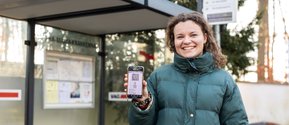 Johanna Schudnagis zeigt ihr Deutschlandticket an der Bushaltestelle des Krankenhaus Martha-Maria St. Theresien in der Stadenstraße in Nürnberg.