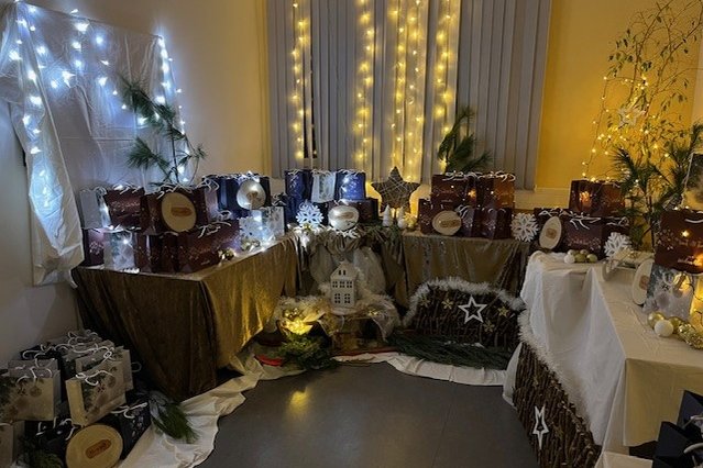 Weihnachtlich dekorierter Raum mit Geschenken und Lichterketten im Seniorenzentrum.
