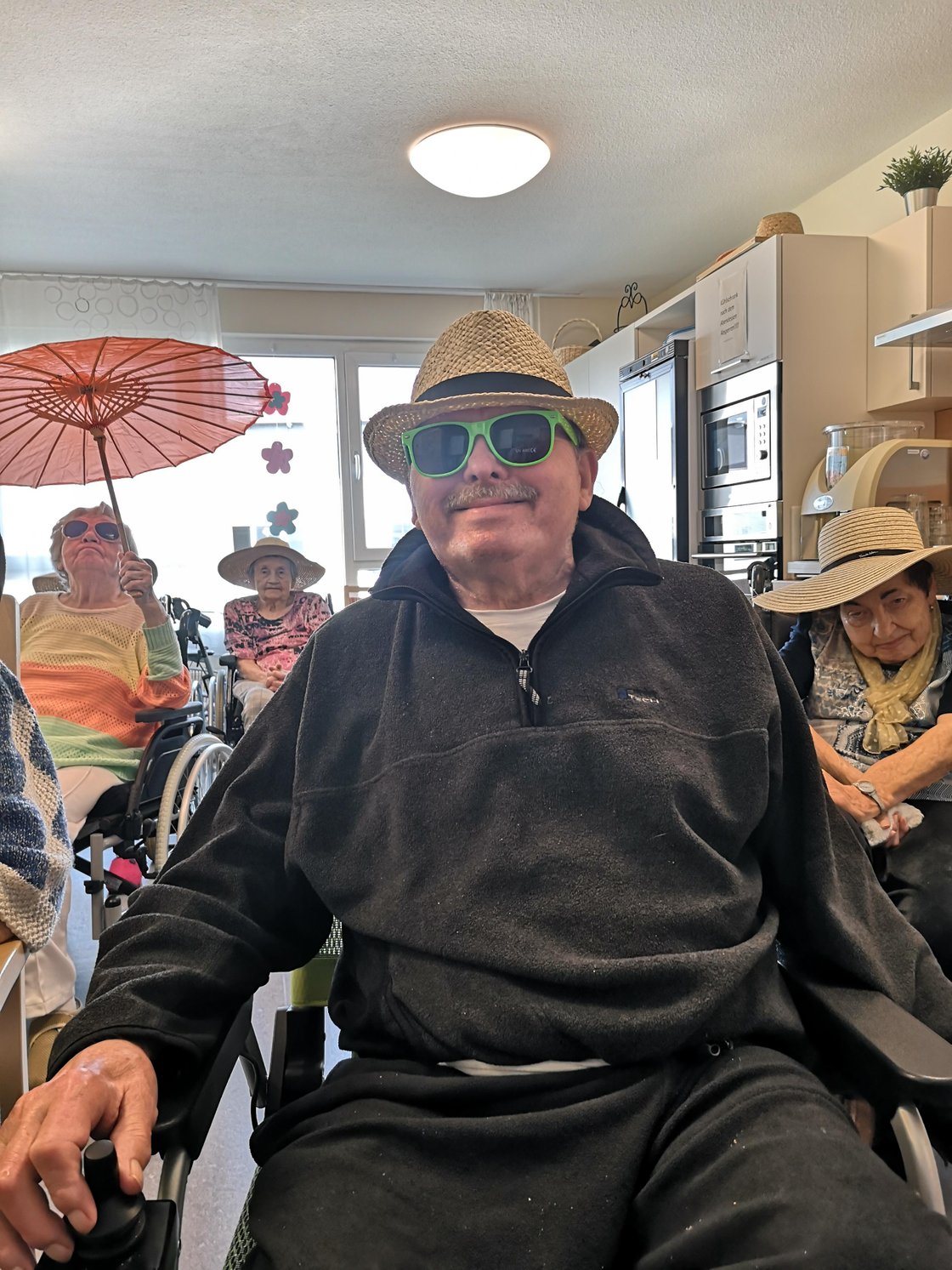 Senioren mit Sonnenbrillen und Hüten im Seniorenzentrum Eckental, fröhliche Atmosphäre.