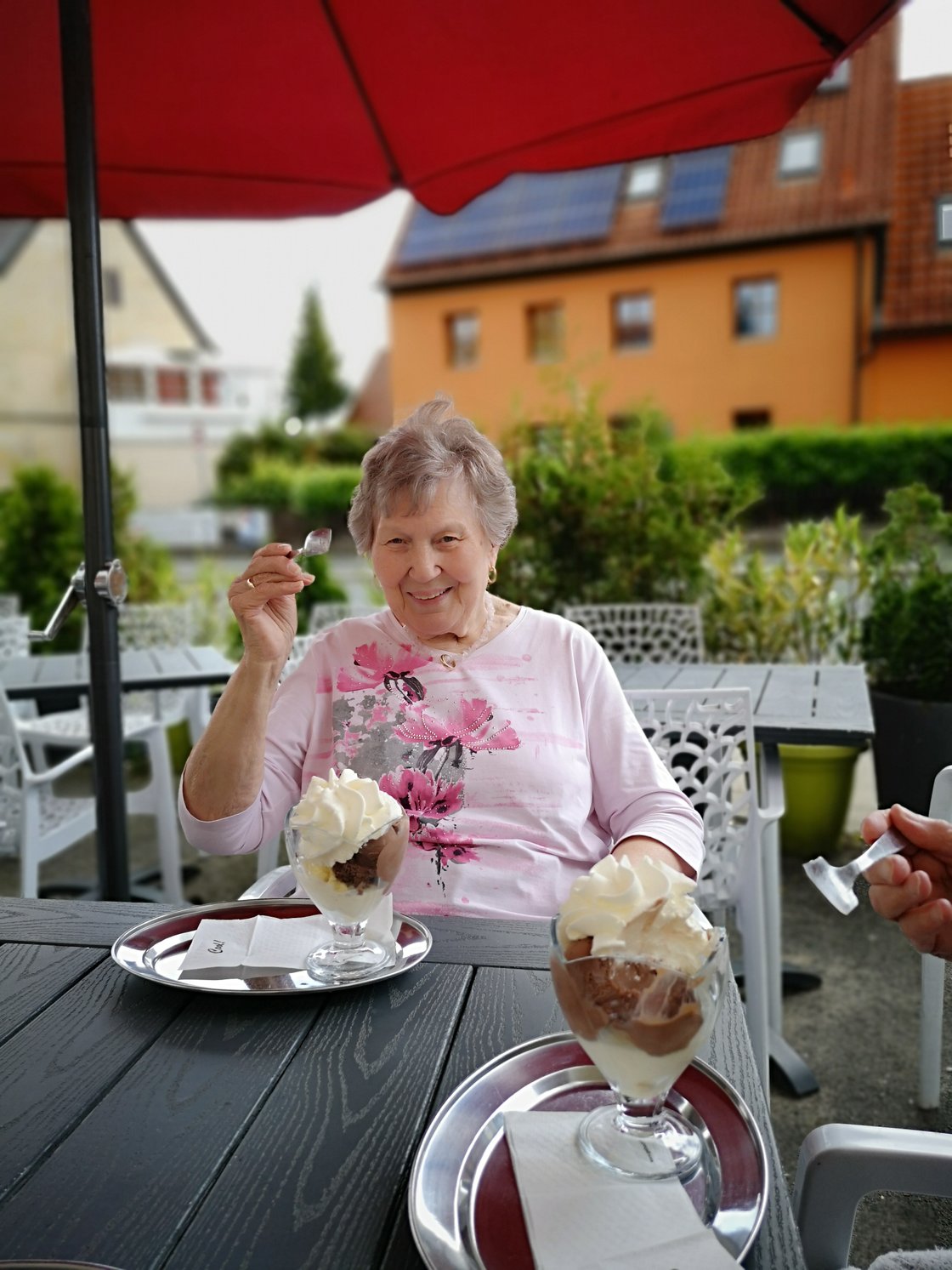 Ältere Frau genießt Eis im Garten des Seniorenzentrums Eckental.