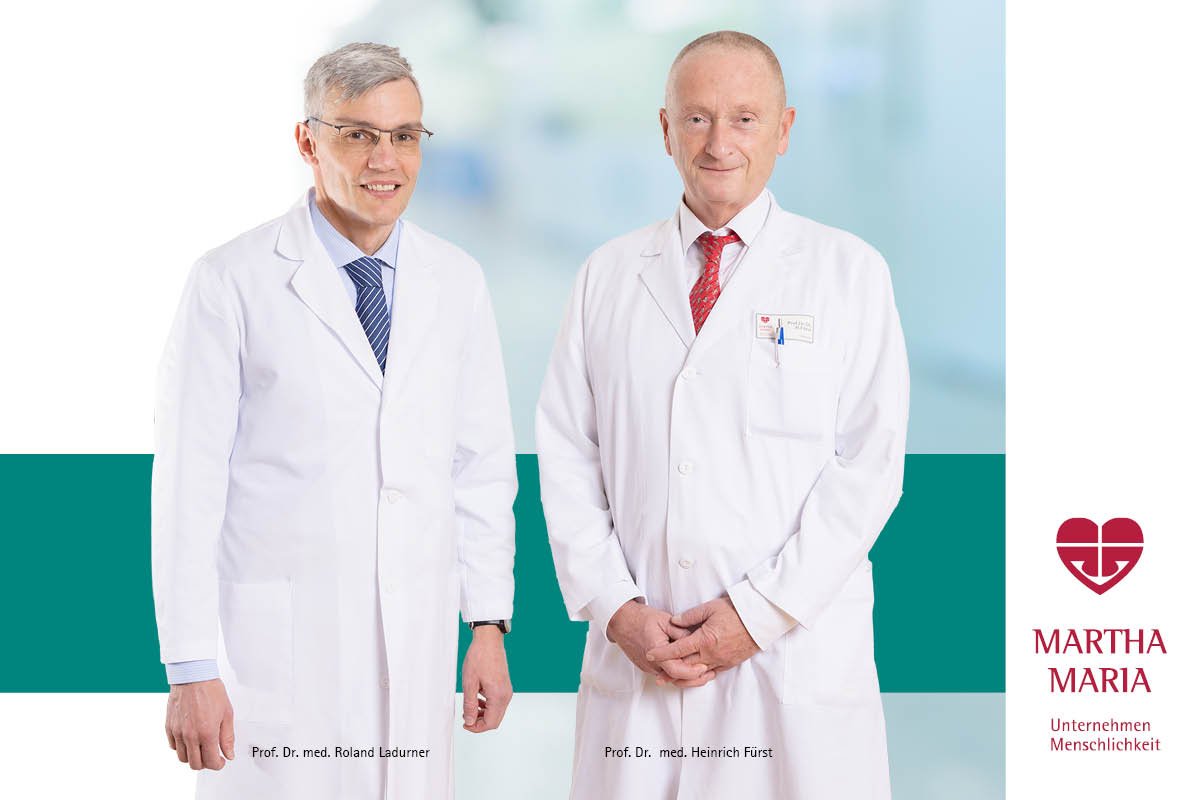Zwei Ärzte in weißen Kitteln vor unscharfem Hintergrund, Martha Maria Logo rechts.