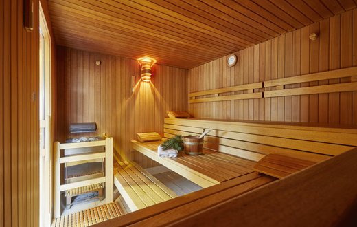 Innenansicht einer Sauna mit Holzbänken und Saunaofen in Klinik Hohenfreudenstadt.