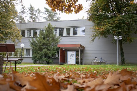 Berufsfachschule für Pflege im Herbst, umgeben von Laub und Bäumen.