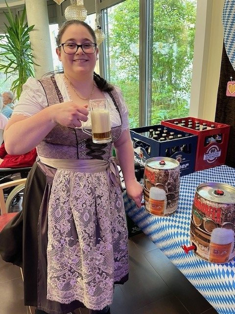 Frau in traditioneller Tracht serviert Bier im Seniorenzentrum Eckental.