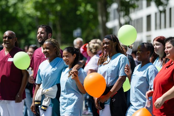Mitarbeiter des Diakoniewerks bei einem Outdoor-Event mit Luftballons.