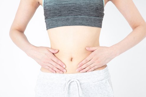 Frau hält Hände auf Bauch, symbolisiert Gesundheit und Viszeralchirurgie.