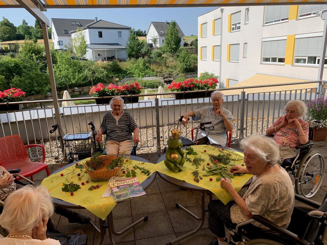 Seniorinnen im Garten des Seniorenzentrums Eckental, genießen sonnigen Nachmittag.