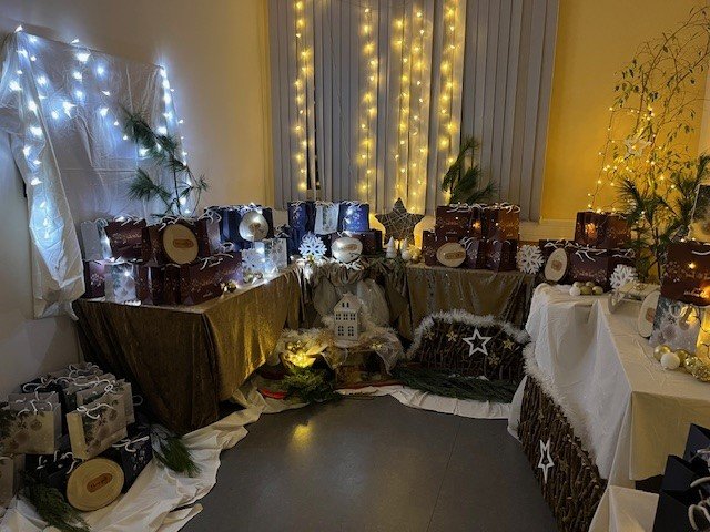 Weihnachtlich dekorierter Raum mit Geschenken und Lichterketten im Seniorenzentrum.