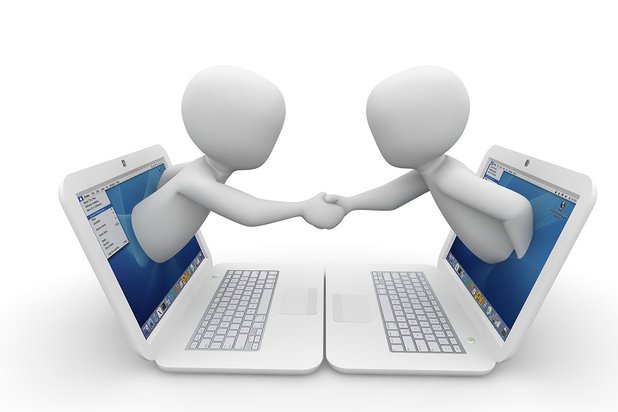 Zwei 3D-Figuren reichen sich Hände aus Laptop-Bildschirmen, symbolisieren Online-Zusammenarbeit.