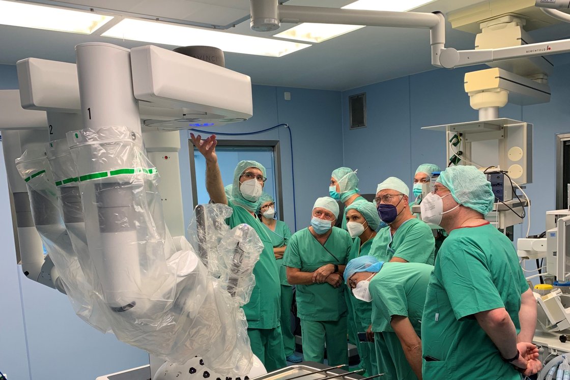 Ärzte in OP-Kleidung bei einer Roboterchirurgie-Schulung im Operationssaal.