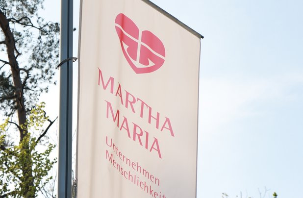Das Martha-Maria-Logo auf einer Fahne vor einer Einrichtung