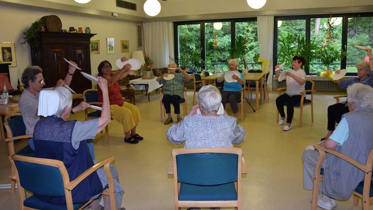 Senioren üben Gymnastik mit Papptellern im Seniorenzentrum Nürnberg.