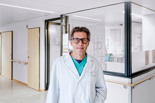 Arzt im weißen Kittel steht im Flur der HNO-Klinik München.