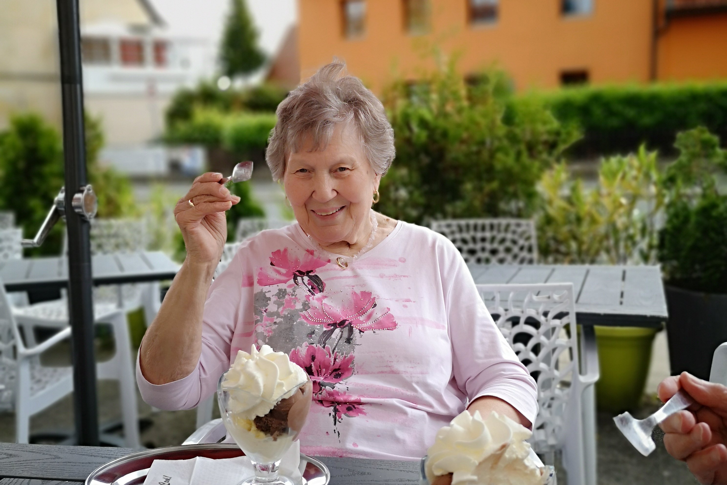 Ältere Frau genießt Eis im Garten des Seniorenzentrums Eckental.