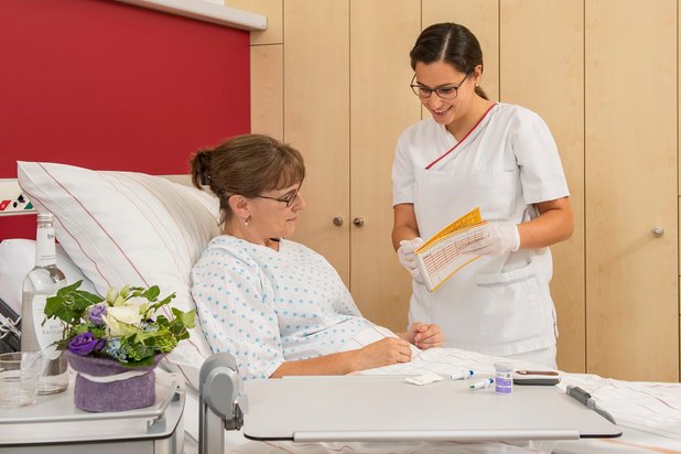 Pflegekraft bespricht Medikamentenplan mit Patientin im Krankenhaus Martha-Maria.