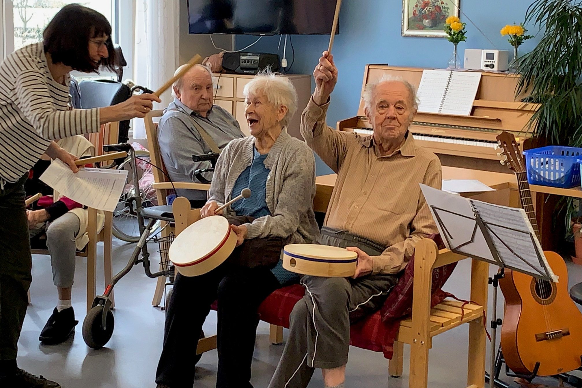 Senioren im Seniorenzentrum Eckental bei Musiktherapie mit Trommeln.