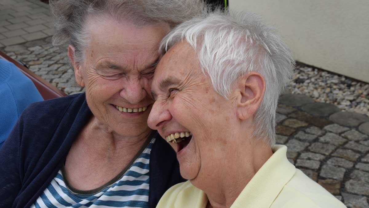 Zwei lachende Seniorinnen im Seniorenzentrum Nürnberg, vereint in Freude.