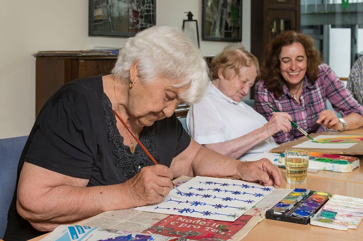 Seniorinnen bei Maltherapie im Seniorenzentrum Stuttgart, malen mit Wasserfarben.