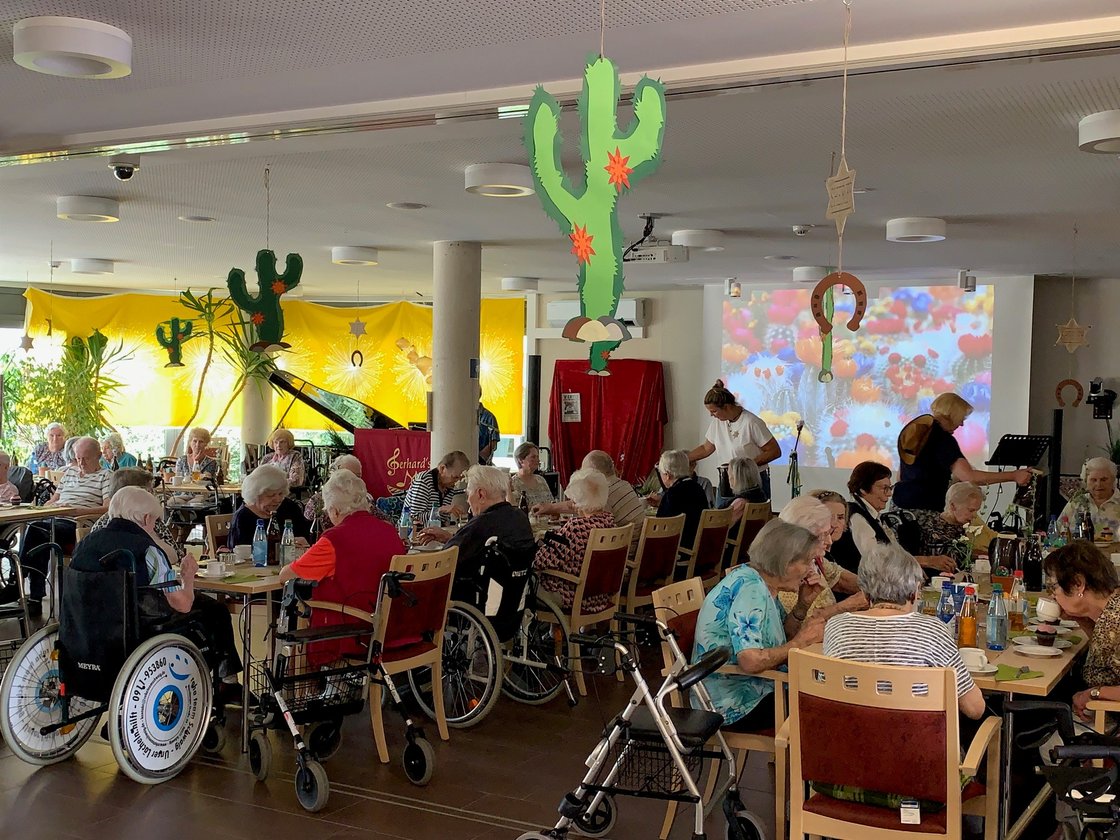 Senioren im Gemeinschaftsraum des Seniorenzentrums Eckental, dekoriert mit Kakteen.